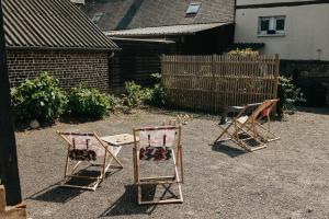 a group of three chairs sitting in a yard at Le Comptoir de Constantin in Le Bourg-Dun