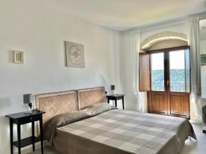 a bedroom with a bed and a large window at Dimore Hyblon in Cassaro