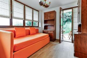 an orange couch in a living room with windows at Il Borghetto di Castagnole in Castagnole Monferrato