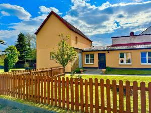 une maison avec une clôture en bois devant dans l'établissement Ferienhaus Havelzeit in Werder an der Havel, à Glindow