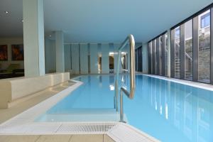una gran piscina de agua azul en un edificio en Park-Hotel Hübner en Warnemünde