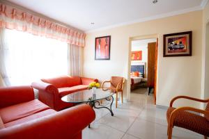 索韦托Emthonjeni Bed & Breakfast的客厅配有红色的沙发和桌子