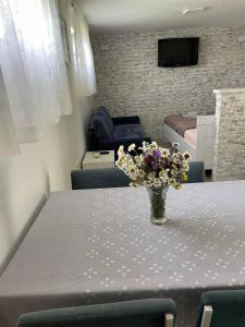 a vase of flowers on a table in a room at Montenegro High Mountain Apartment in Žabljak