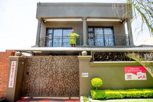 索韦托Emthonjeni Bed & Breakfast的站在房子阳台上的人