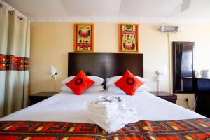 索韦托Emthonjeni Bed & Breakfast的卧室里有一张大床，配有红色枕头