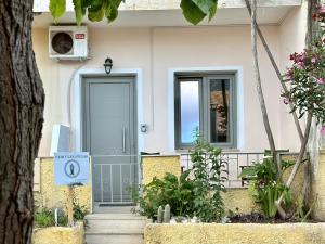 a house with a blue door and a window at Hercules Studio in Vasiliki