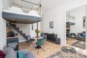 a living room with a couch and a table and a staircase at V62 studio apartments- Downtown Sopron in Sopron