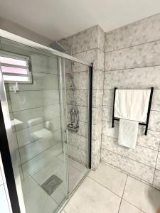 a shower with a glass door in a bathroom at La Serena de Toumalacai, Piscine, Plage, Tennis in Grand-Bourg +26 photos