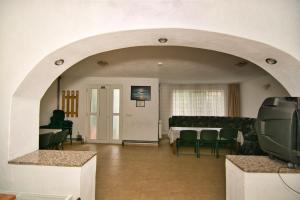 a living room with an archway and a table and chairs at Casa Sima in Călimăneşti