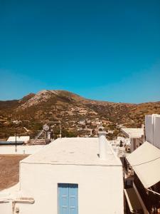 a white building with a blue door in front of a mountain at Amersa's House in Skiros