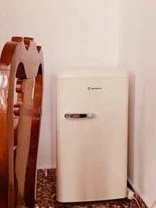 a small white refrigerator sitting next to a wall at Amersa's House in Skiros