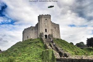 a castle on top of a hill with a flag at Neighbourhood Bedrooms in Cardiff