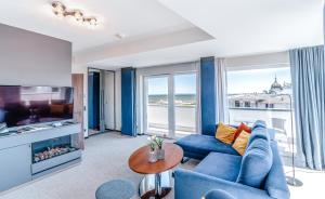 阿爾貝克的住宿－達斯阿爾貝克酒店及SPA，客厅配有蓝色的沙发和电视