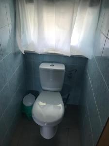 a bathroom with a white toilet and a window at Tanie Pokoje Kajetany in Kajetany