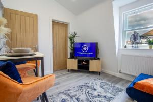 a living room with a tv and a table at The Lanes Luxury - Rose Platinum Properties in Brighton & Hove