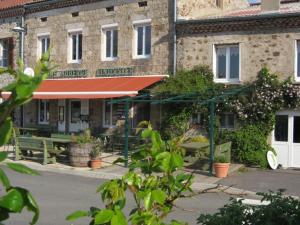 a building with a table and benches in front of it at Ferme Auberge Linossier in Burdignes