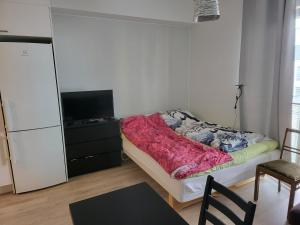 a small bedroom with a bed and a television at Apartment near the Harbour in Turku