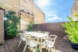 a white table and chairs on a patio at Magnifiques Appartements sur les Quais de Bordeaux in Bordeaux +70 photos