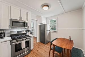 a kitchen with a table and a stove and refrigerator at The Stables by Saratoga Stays in Saratoga Springs
