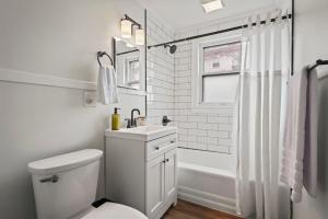 a white bathroom with a toilet and a sink at The Stables by Saratoga Stays in Saratoga Springs +15 photos