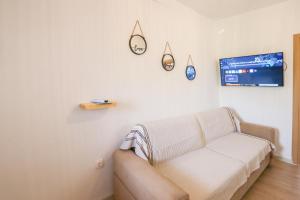 a living room with a couch and a tv at Vraxlida Living in Himare
