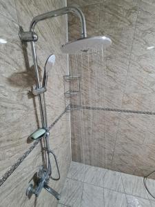een douche met een douchekop in een badkamer bij Green villa in Gabala