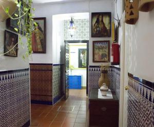 Habitación con un pasillo con pinturas en las paredes. en Pensión Santa María la Blanca, en Sevilla