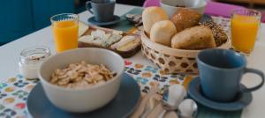 una mesa con desayuno de pan y zumo de naranja en Hostal Vidamia en Málaga