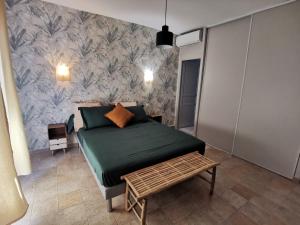 a bedroom with a green bed and a wall at Le Loriot in Auriol +35 photos