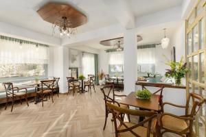a dining room with tables and chairs and windows at Meydani Suites in Litochoro