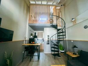 a spiral staircase in a living room with a kitchen at Gardy rooms in Nea Kallikrateia
