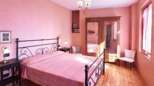 a bedroom with a bed with a pink bedspread at Terrazza in Cissano