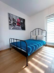 a bedroom with a bed with blue sheets and a red truck at AlfaHome Neopolis Parking in Łódź