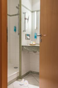 a bathroom with a shower and a sink at Strand-Hotel Hübner in Warnemünde