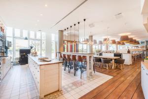 a kitchen with a bar and a dining room at Strand-Hotel Hübner in Warnemünde
