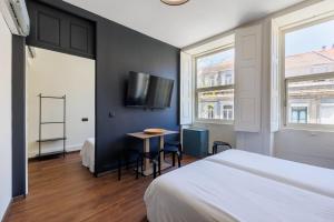 Un dormitorio con una cama, una mesa y un televisor. en Cosme Apartments by Olala Homes, en Oporto