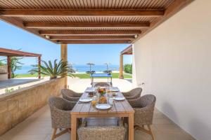 キオタリにあるParadise Beach Iのテーブルと椅子と海のあるダイニングルーム