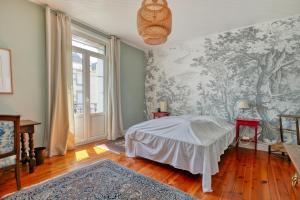 a bedroom with a bed and a wall mural at Maison Albizia in Le Croisic