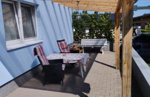 a patio with a table and chairs and a bench at Gästehaus mit 3 separaten Schlafbereichen, Terrasse und Carport in Velten +7 photos