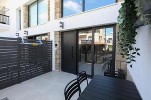 a patio with a black table and chairs at PanMari in Paphos