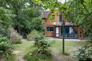 una casa in legno in mezzo a una foresta di Ferienhaus am Brandorffsee a Wiefelstede