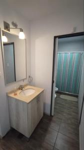 un baño con lavabo y espejo en Amplia casa en La Falda, en La Falda
