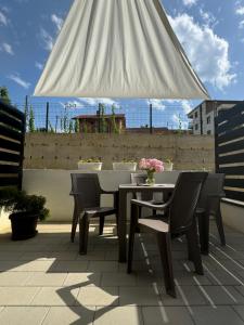 a table and chairs on a patio with a white umbrella at Apartmani Viver Vrnjačka Banja in Vrnjci