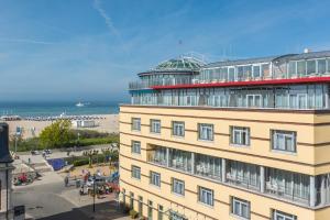 a building with a beach in the background and a building at Strand-Hotel Hübner in Warnemünde