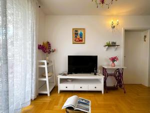 a living room with a television on a white cabinet at Apartment Second Home in Tribunj