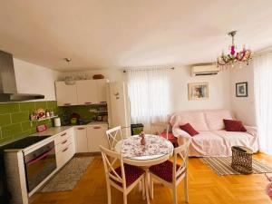 a kitchen and living room with a table and chairs at Apartment Second Home in Tribunj