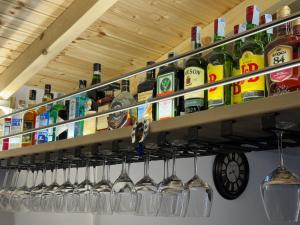 Ein Haufen Weinflaschen und Gläser auf einem Regal. in der Unterkunft Hotel Cekodhima in Vlorë