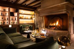 - un salon avec un canapé et une cheminée dans l'établissement Hostellerie Briqueterie & Spa Champagne, à Vinay