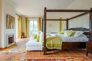 Un dormitorio con una cama con dosel y una chimenea. en Luxurious sprawling villa in Praia Del Rey, en Amoreira 60 fotos más