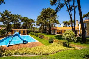 una piscina con un tobogán en un patio en Luxurious sprawling villa in Praia Del Rey, en Amoreira